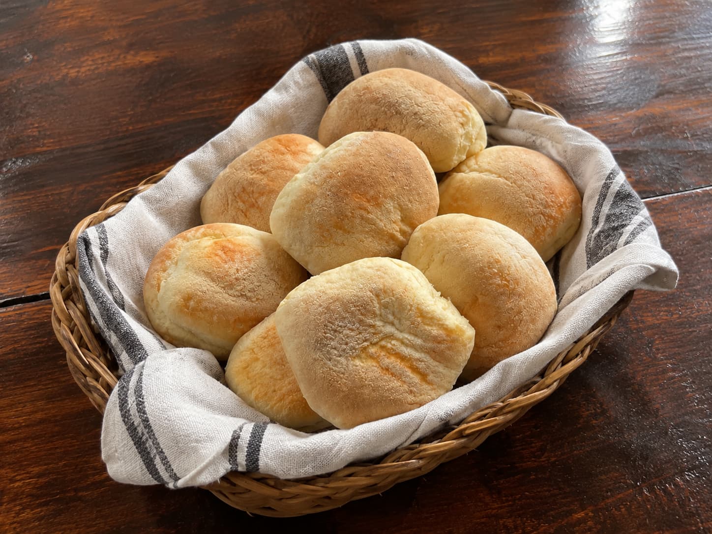 Panera de mimbre con pan amasado casero sobre un paño de cocina